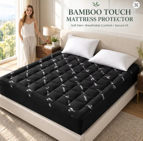 Black quilted mattress topper on a bed
